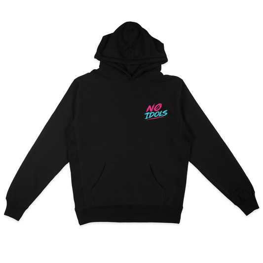 A black pullover hoodie with a small 'NO IDOLS' graphic printed on the left chest in pink and teal, displayed flat against a solid white background.